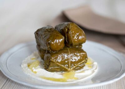 Stuffed grape leaves on a white plate from Kyma